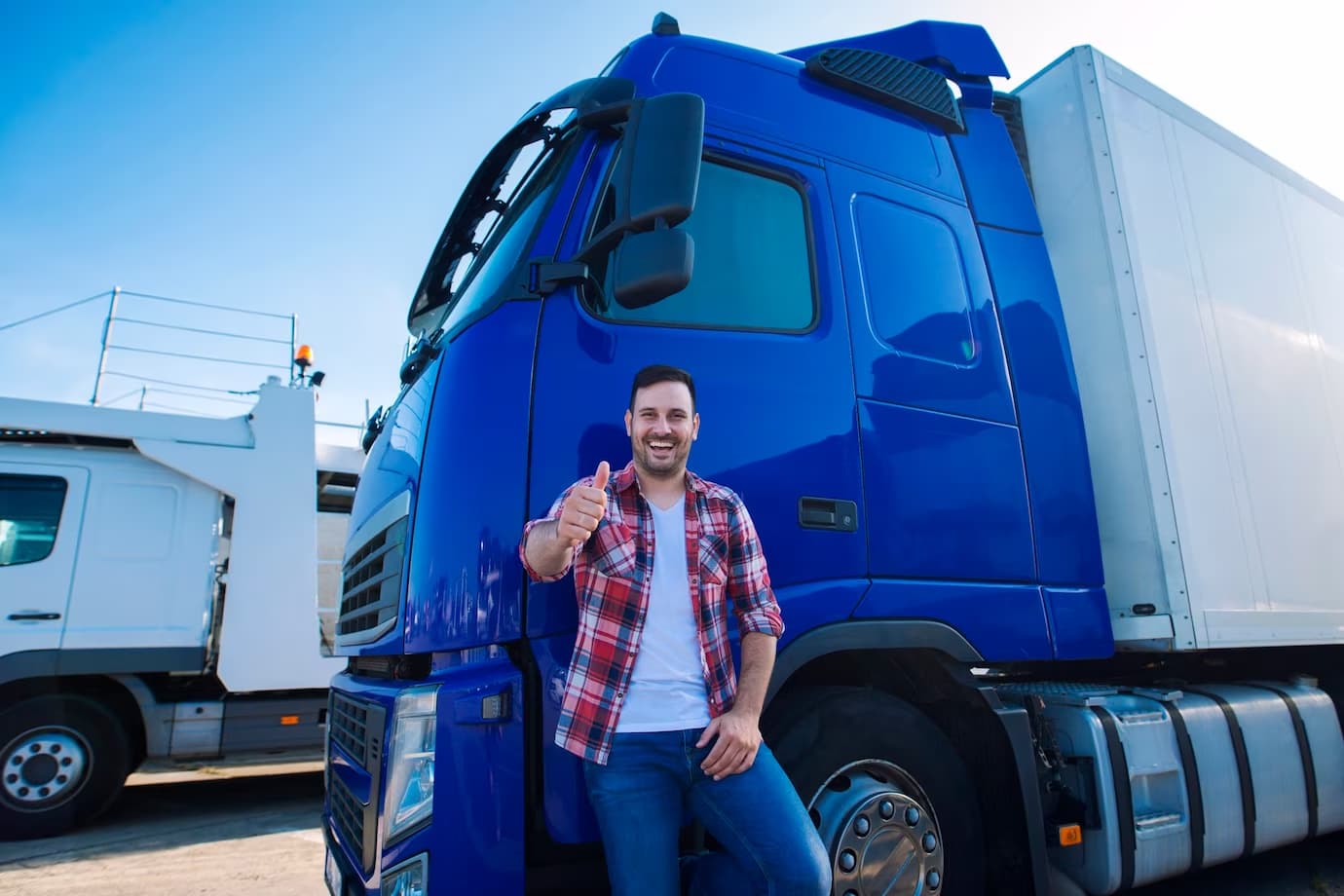 Fleet driver standing beside a blue semi truck